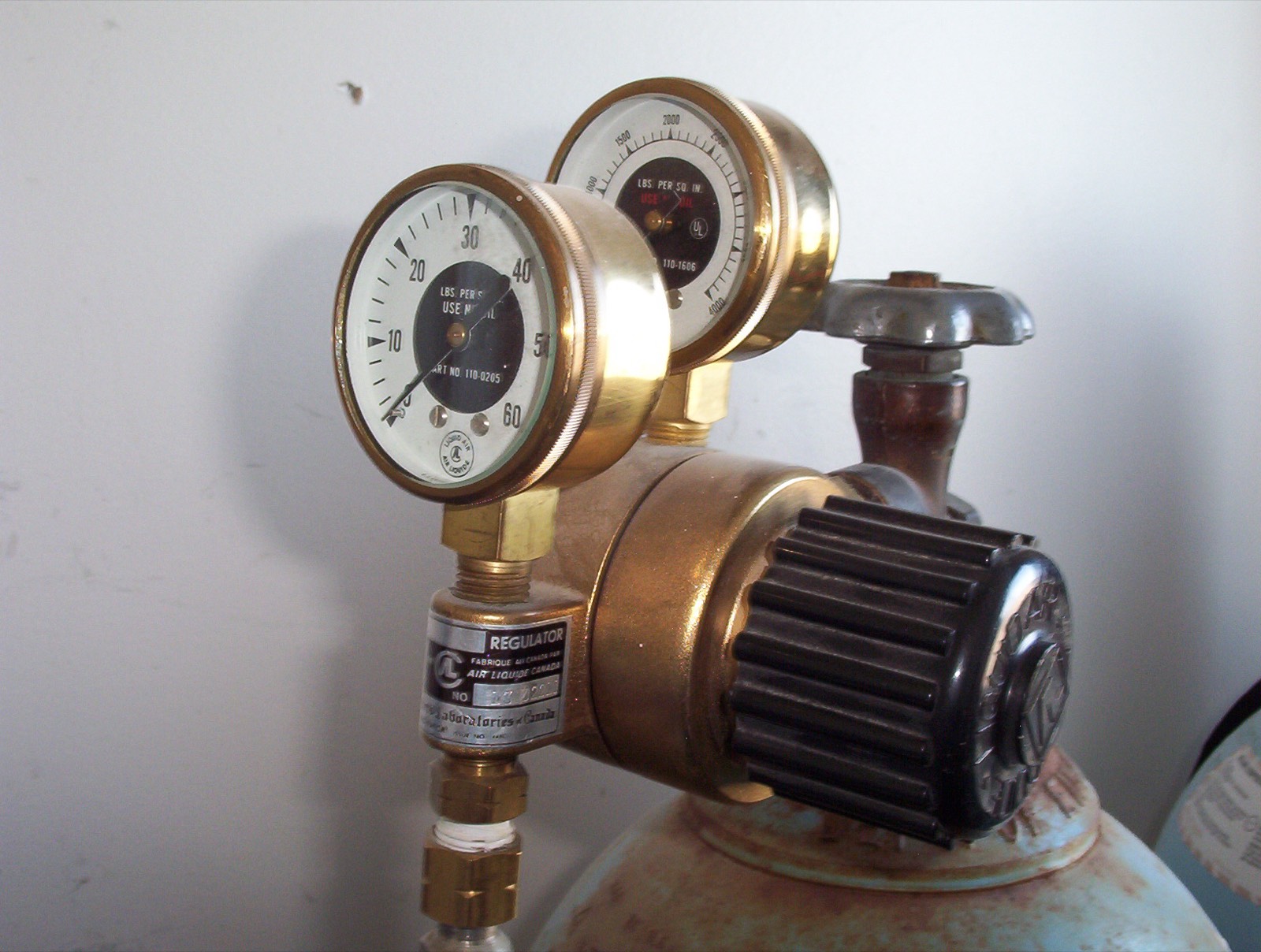 Close-up of a regulator valve and pressure gauge on a pipe