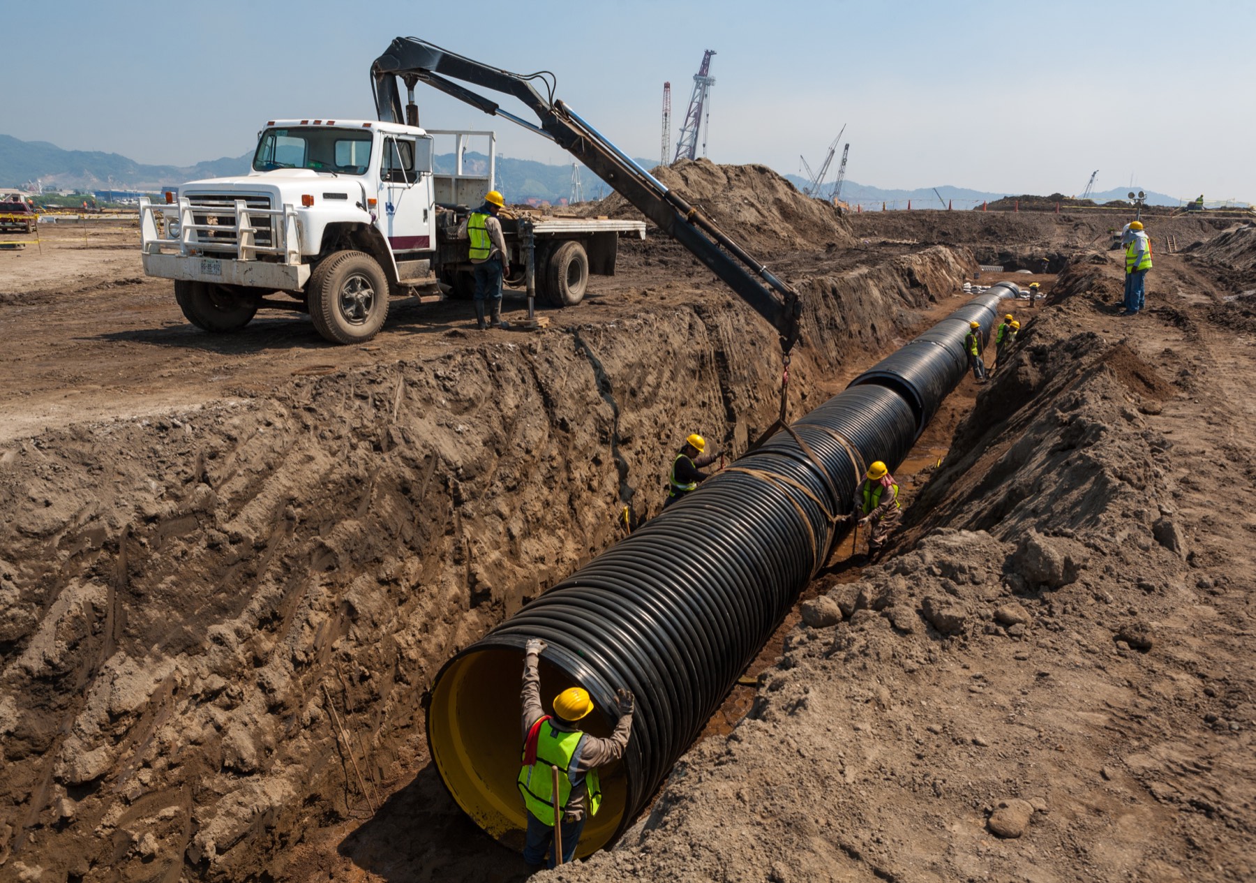 Large HDPE water pipe being positioned by crane during installation